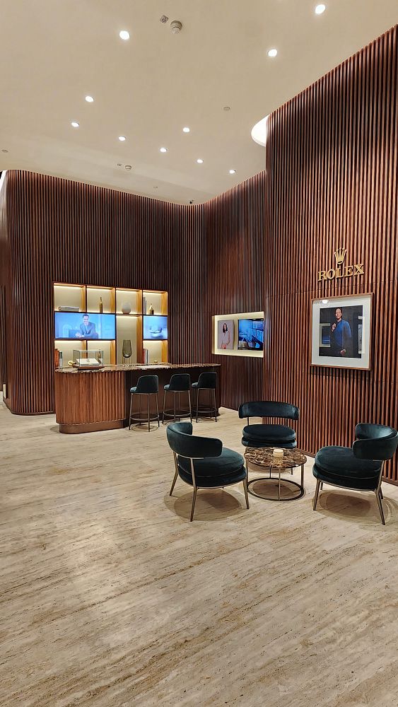 A luxurious interior of a Rolex boutique featuring elegant seating and display areas.