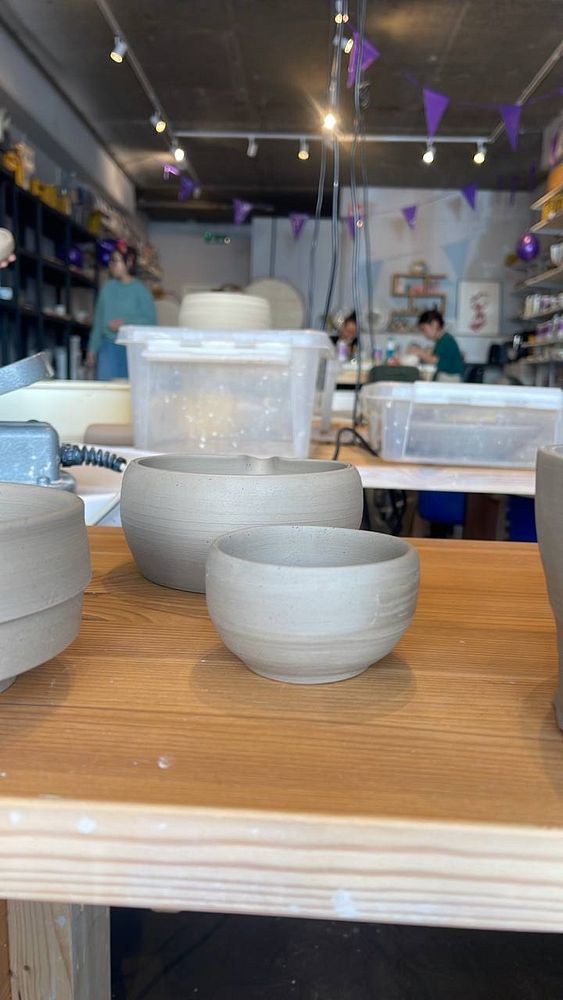 A cozy domestic scene featuring pottery work with a girlfriend, including a man sculpting clay in a living room setting.