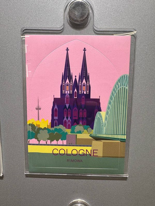 A colorful card featuring a stylized illustration of Cologne's skyline.