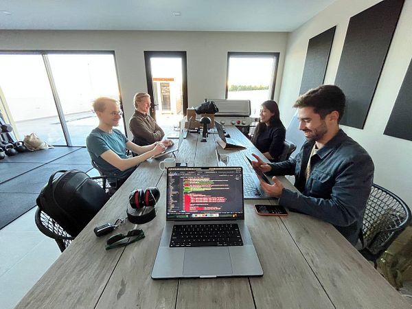 A group of four individuals is engaged in a coworking session at a modern workspace.