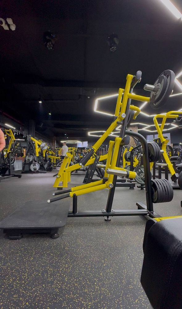 A modern gym interior featuring various weightlifting equipment.