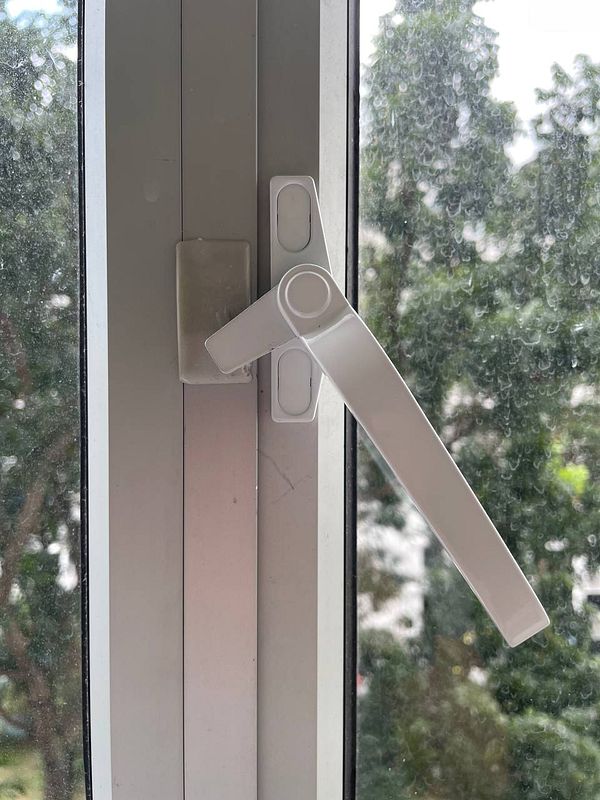 A close-up view of a window handle that is broken and needs replacement.