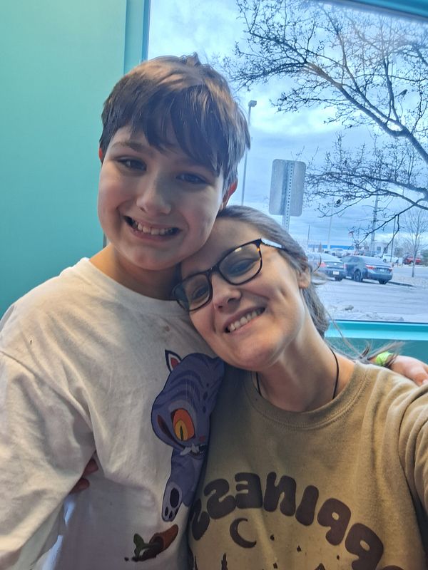 A group of children jumping energetically on red trampolines inside a trampoline park with padded walls and colorful decorations.