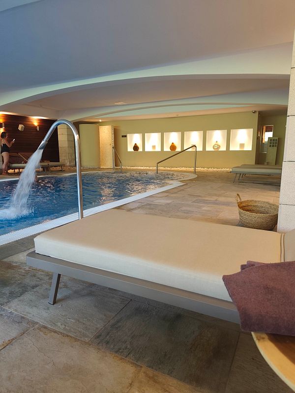A relaxing breakfast and spa setting featuring a food tray, a hot beverage, and a candle-lit ambiance.