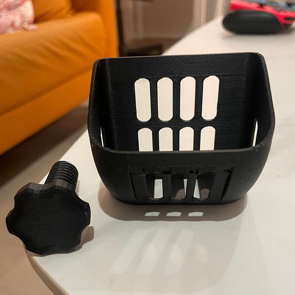 A 3D printer printing a pink, complex geometric object with curved and lattice patterns.