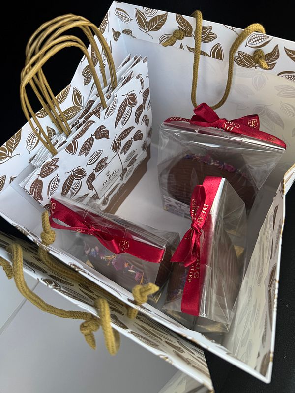 A beautifully arranged gift bag containing chocolate eggs and treats.