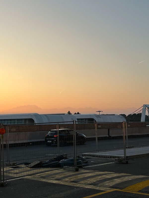 A serene sunset view over distant mountains, with construction elements in the foreground.