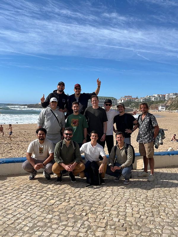 A lively group photo of about twenty people gathered at an indoor event celebrating Ruby on Waves #1 with diverse attendees from various locations.