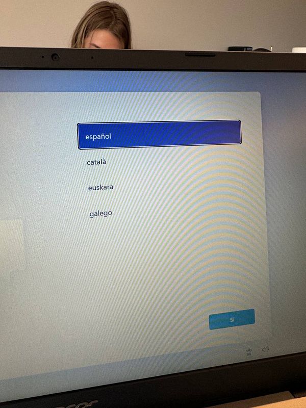 The image displays a laptop screen showing a language selection menu.