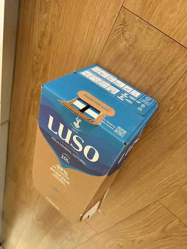 A 10L Luso water box is positioned upright on a wooden floor.