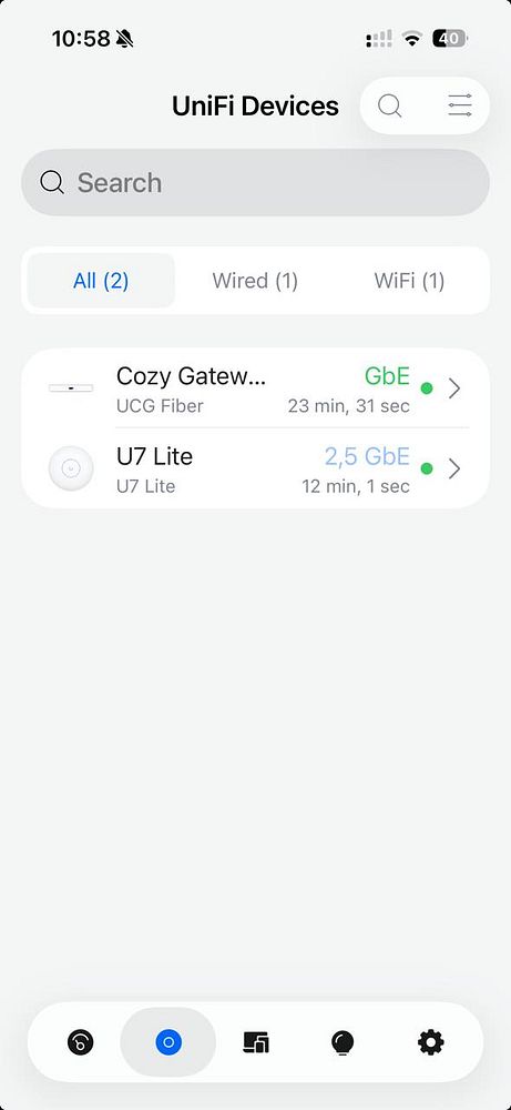 Photograph of a network setup focus area with a router, networking cables, and a mounted white device on a wall.