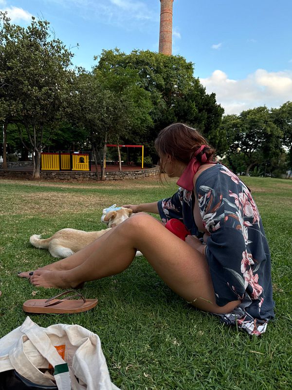 A woman enjoys a relaxing day at the park with her dog.