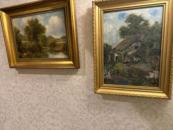 A cozy colonial-style hotel room with vintage furniture and Dutch paintings.