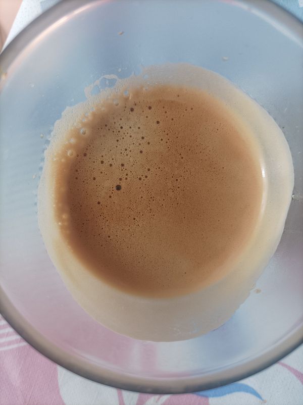 A close-up view of a cup of espresso with a creamy froth on top.