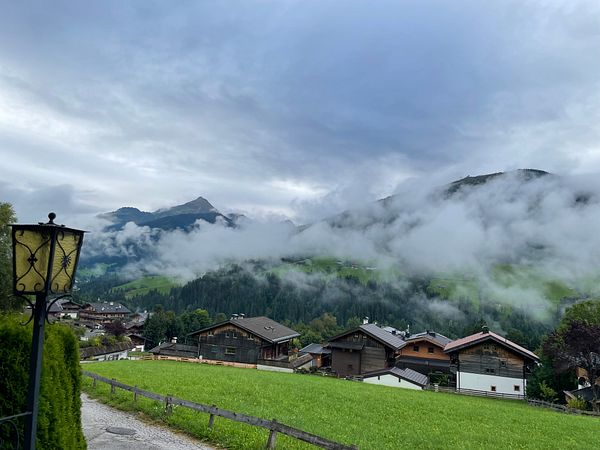 A serene mountain landscape with mist and houses nestled in the valley.