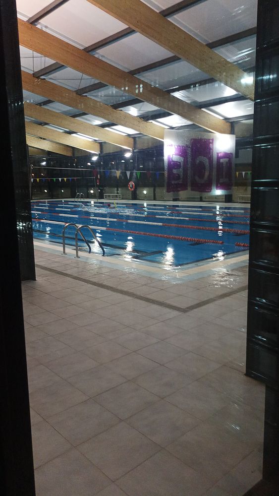 An indoor swimming pool is visible, illuminated and ready for use.