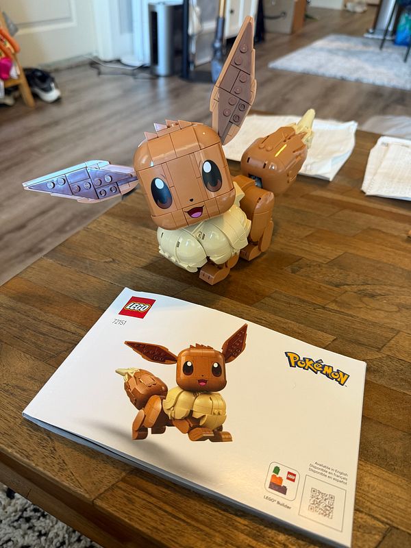 A completed Espeon Lego figure from the Pokemon series posed against a reflective background.