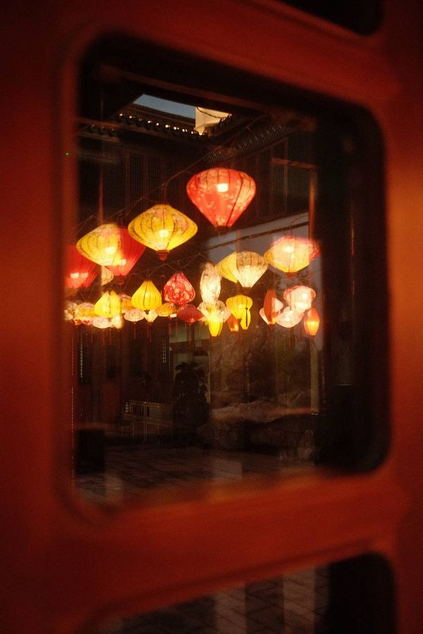 Scenic view of Xianghu Lake with wooden walkway, water reflections, and surrounding nature under a partly cloudy sky.