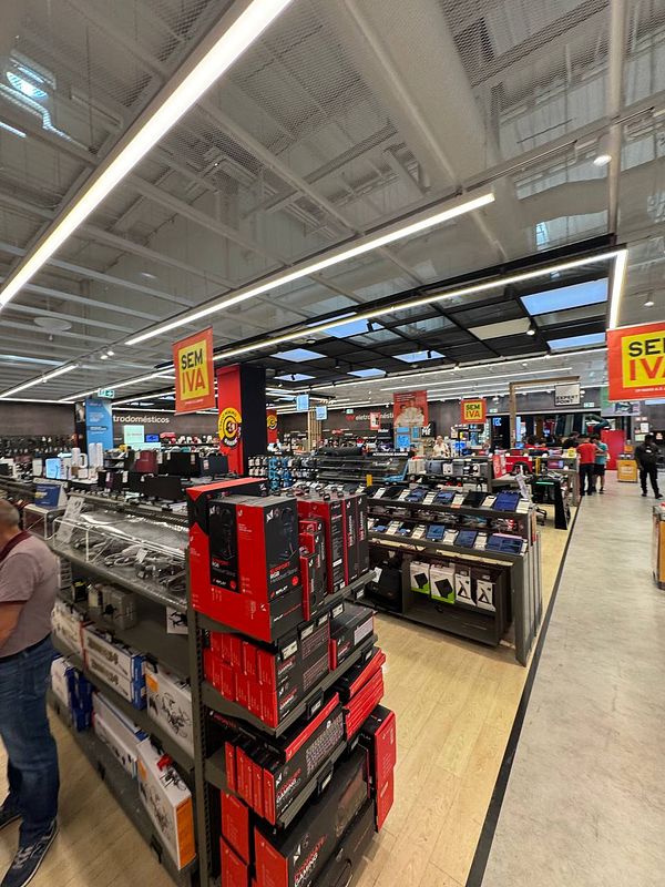 A busy electronics store interior with visible product displays and customers.