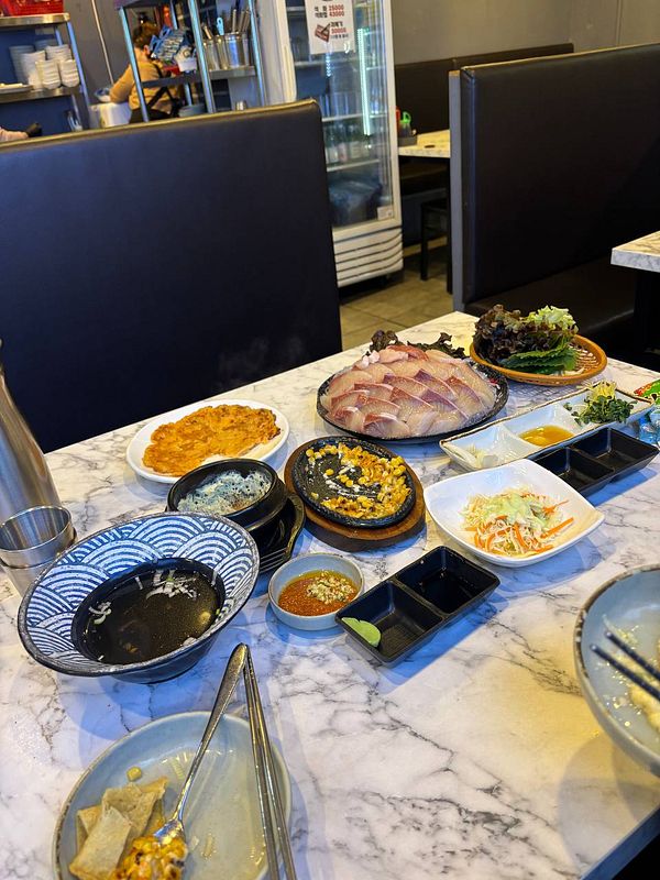 A table filled with various dishes featuring Japanese amberjack and other accompaniments.