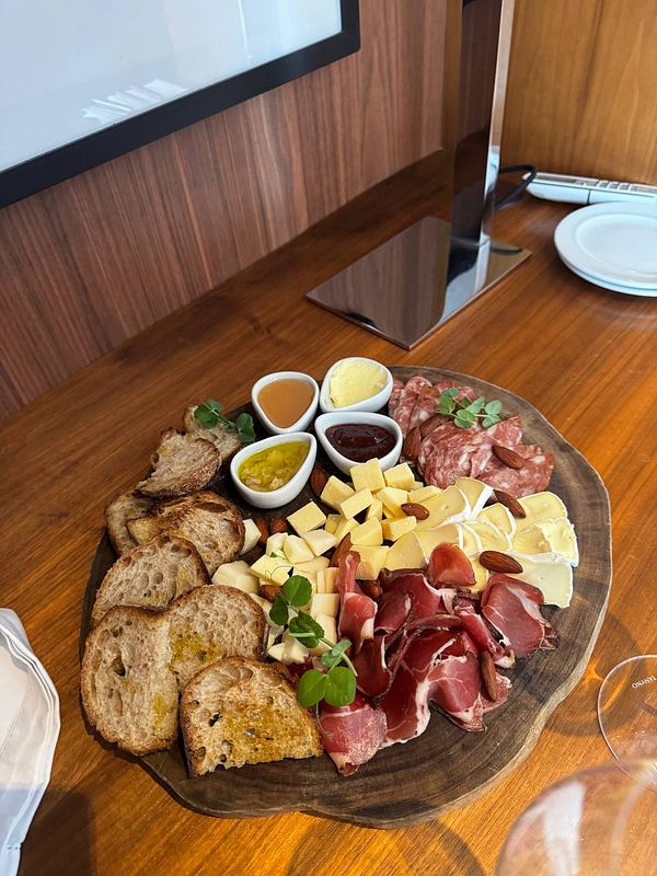 A beautifully arranged charcuterie board featuring various meats, cheeses, and accompaniments.