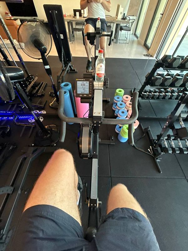 A person is using a rowing machine in a home gym setting.