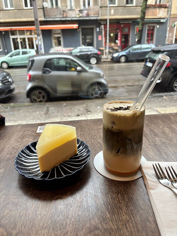 Interior of a Vietnamese café with patrons eating and drinking at wooden tables under warm lighting.