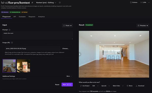 The image displays a modern, empty room with a kitchen area and wooden flooring.