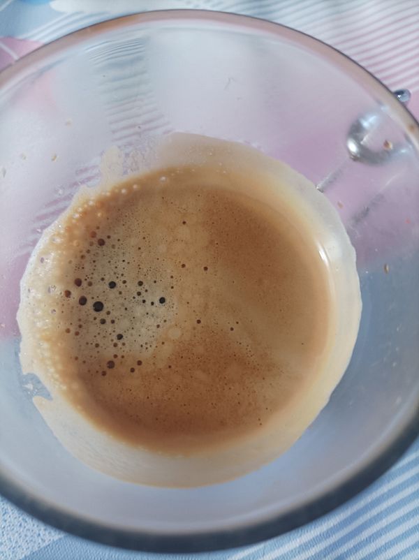 A close-up view of a glass containing freshly brewed espresso.