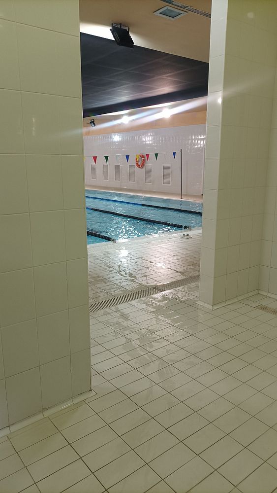 A view of an indoor swimming pool from a changing area.