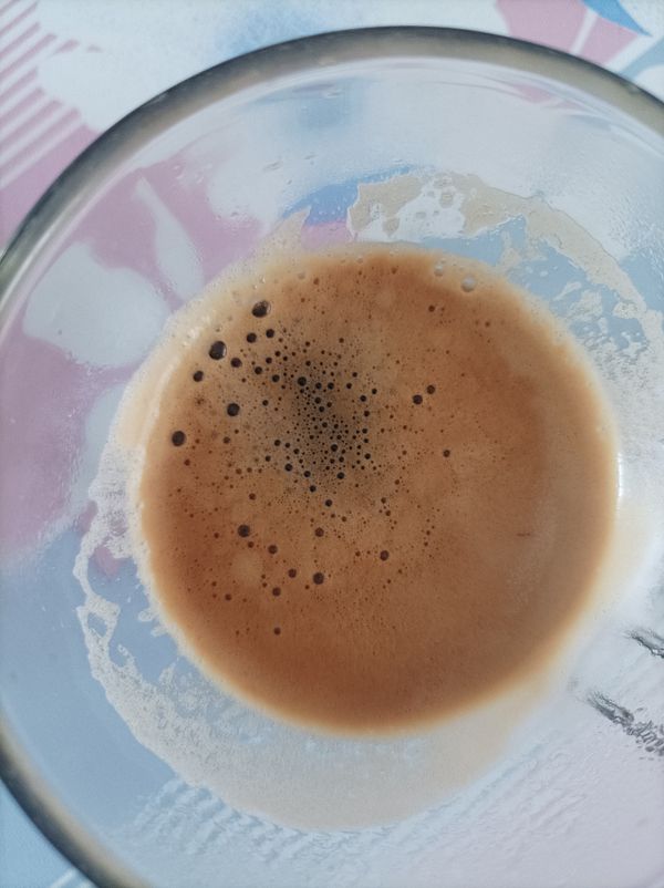 A close-up view of a glass containing freshly brewed espresso.
