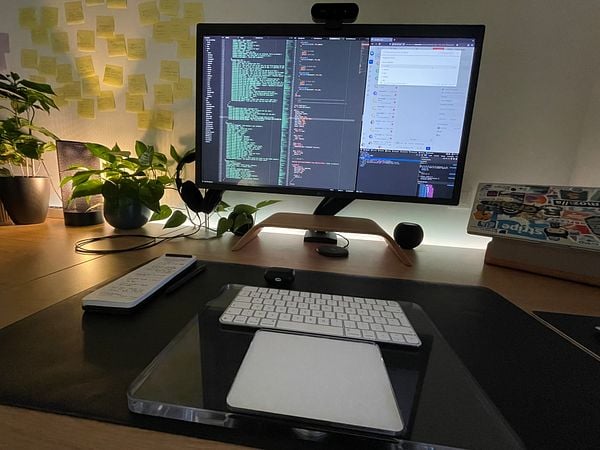 A cozy workspace featuring a dual-monitor setup with coding and communication applications open.