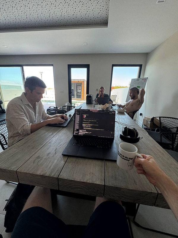 A group of three people is working together in a modern coworking space.