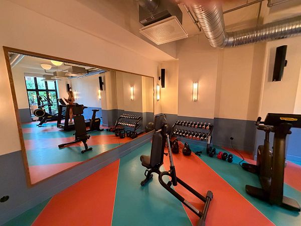 Modern gym facility interior featuring multiple exercise machines and equipment arranged in a spacious, well-lit room.