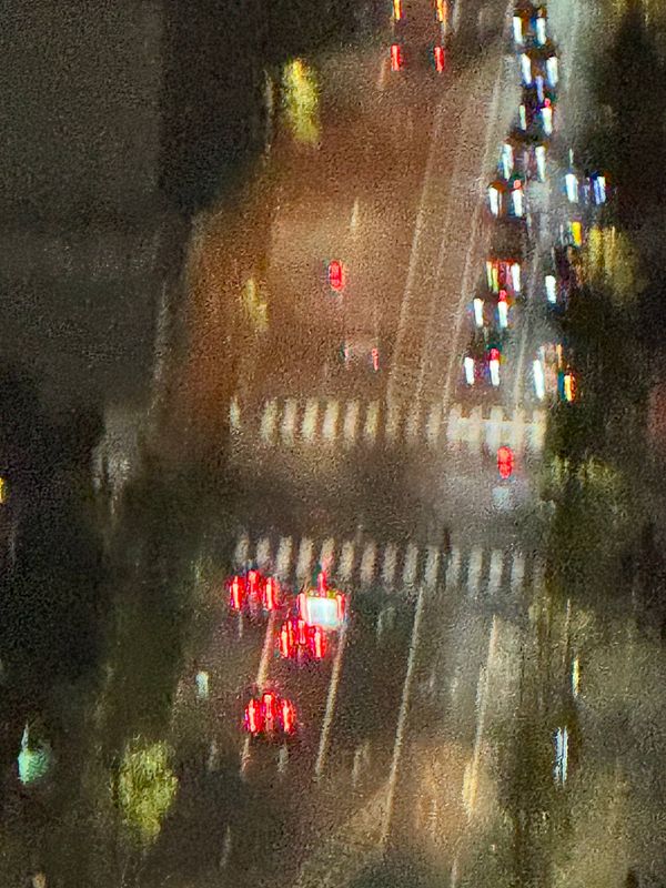 A nighttime view of a busy street intersection with blurred lights from vehicles.