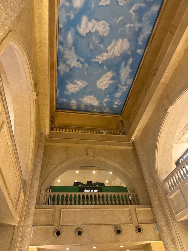 The image captures the interior architecture of a building with a decorative ceiling and arched structures.
