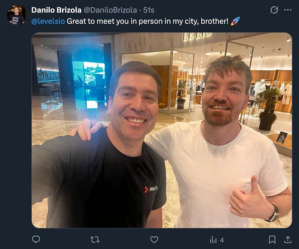 A selfie of two men smiling at the camera inside a shopping mall.