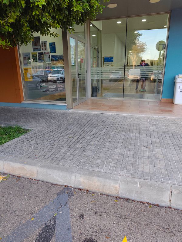 Athlete running outdoors on a sunny day next to a wooden railing overlooking a body of water.
