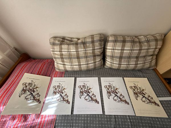 A collection of eight different printed sheets showcasing a variety of print styles and colors on various types of paper arranged on a flat surface.