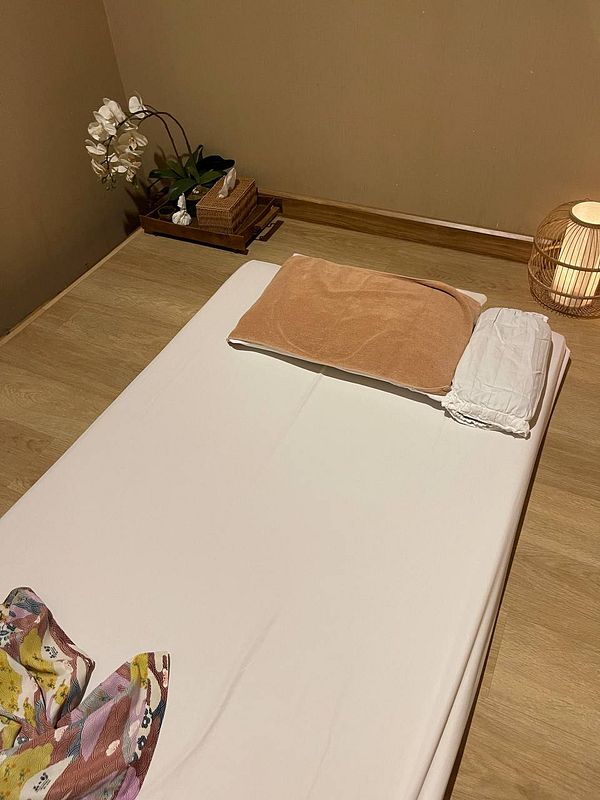 A serene onsen room setup featuring a massage bed and calming decor.