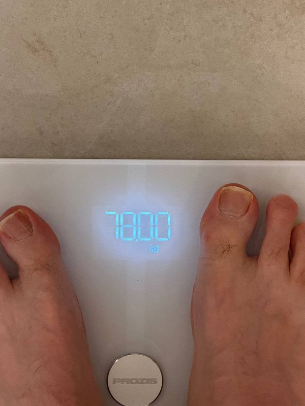 The image displays a digital scale reading 78.0 kg with a person's feet on it.