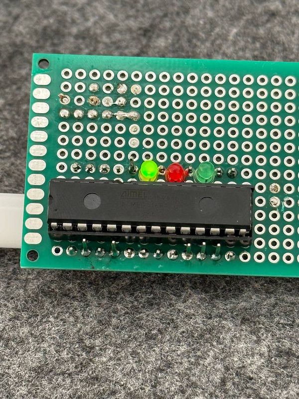 A custom AVR ISP board featuring a DIP socket and indicator LEDs.