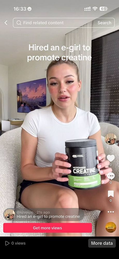 Portrait of a young woman with short brown hair and green eyes, smiling against a white background.