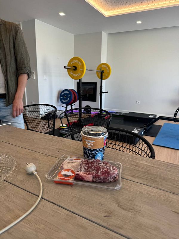 A cozy coworking space featuring workout equipment and food items on a wooden table.