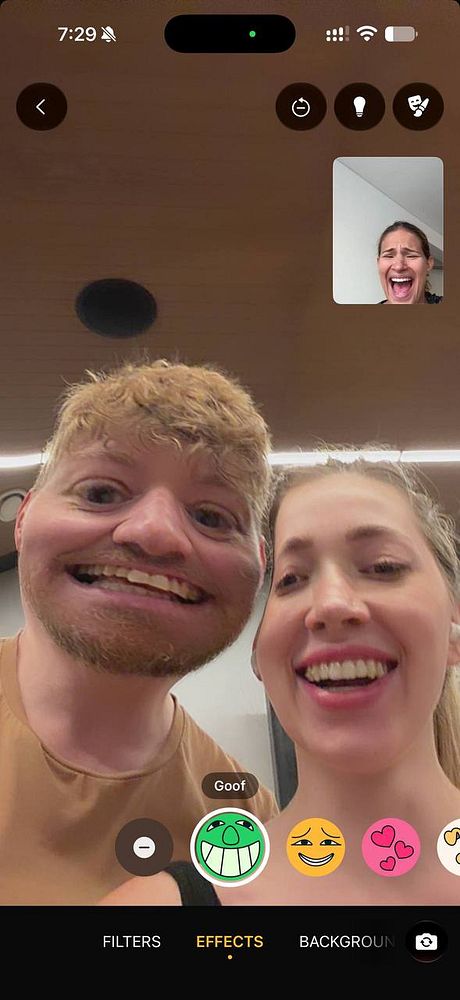 A mobile phone screenshot of a video call with two people using a goofy face filter and a third person in a small window making a laughing expression.