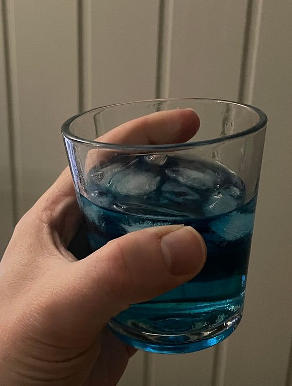 Colorful bedding with playful dinosaur patterns on a bed in a pink-themed room.