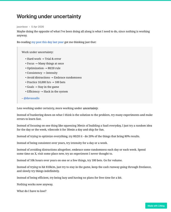 Photograph of a man holding a dog in a natural outdoor setting with trees and fog in the background.