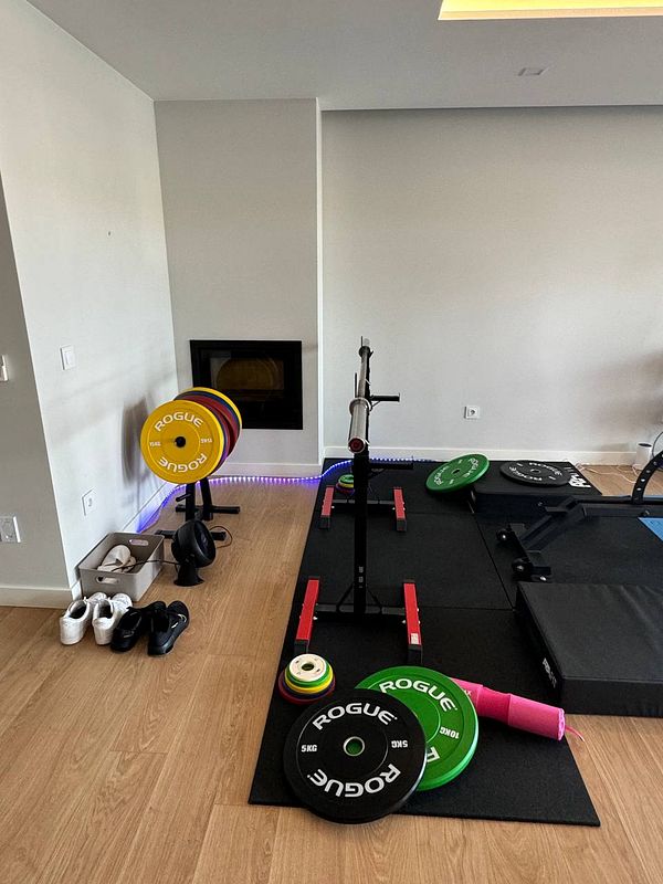 A home gym setup featuring various weightlifting equipment and accessories.