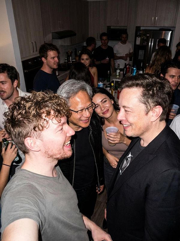 A lively gathering of people at a party, featuring a close-up selfie with notable individuals.