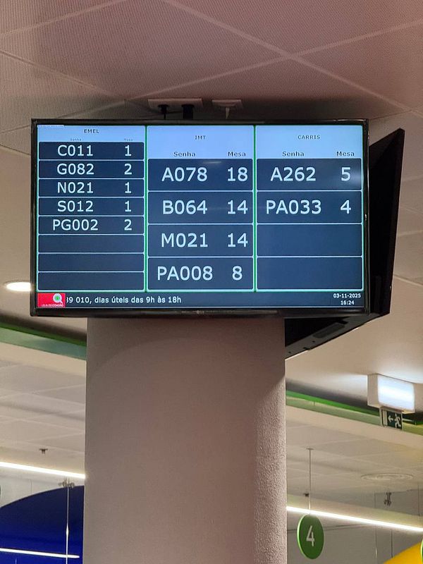 A digital display board at a Portuguese driver license center showing queue information.
